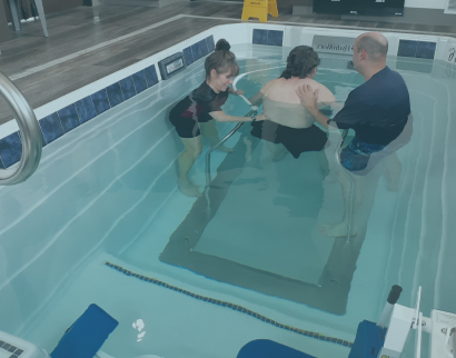 Patient being helped in pool by health care professionals | Middleton PT